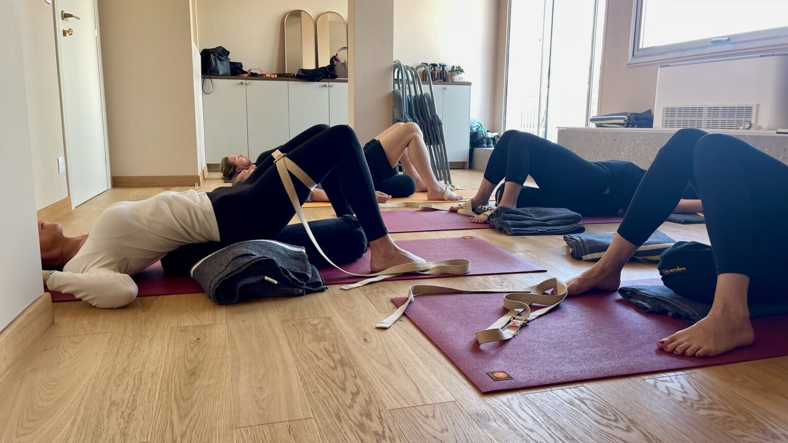 Cours collectif de yoga Iyengar au 29 rue Pastorelli, à Nice : des élèves allongés sur leurs tapis, avec sangles et couvertures.